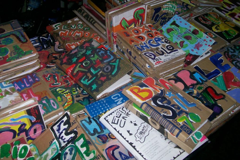 Eloísa Cartonera, an independent book published founded in Argentina in 2002, buys cardboard at fair prices from local cartoneros (often unhoused individuals) to craft uniquely hand-painted books. It has inspired other "cartonera" publishers globally. Photo credit (Creative Commons): https://commons.wikimedia.org/wiki/File:Libros_de_Elo%C3%ADsa_Cartonera_2.jpg